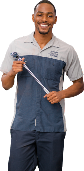Hyundai service technician smiling and holding a tire pressure gauge tool.
