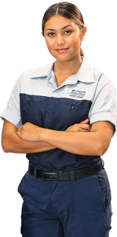 Smiling Hyundai female technician in uniform, standing confidently with arms crossed.